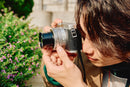 Person taking a photo with a Panasonic l10 silver camera in an outdoor setting By Best camera store toronto