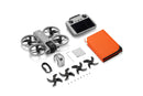 Drone parts including a quadcopter, propellers, and a controller on a white background