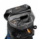 Looking inside the top-loading drawstring compartment of the Lowepro PhotoSport 15L daypack showing a packed down jacket and phone pocket.