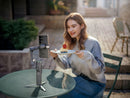 A creator filming a vlog with a Samsung smartphone mounted on the DJI Osmo Mobile 8P on a patio table, sold by Best Camera Store.