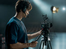 Camera operator using a mirrorless camera mounted with the DJI SDR Transmission 2 transceiver from best camera stores.