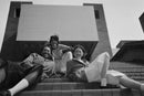 Sample black-and-white group portrait of three friends sitting on stairs, shot using a Fujifilm QuickSnap camera from Best Camera Store.