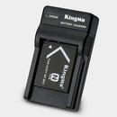 Angled profile view of the KingMa NP-BN1 battery block securely loaded inside the slim travel charging cradle.