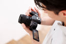 Photographer holding the Tamron 16-50mm f/2.8 lens mounted on a Canon EOS camera body from Best Camera Store.   