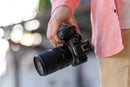 Photographer holding a Canon EOS R7 mirrorless camera body with the Tamron 17-70mm f2.8 lens mounted.