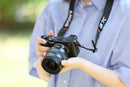 Person holding a Sony camera and Tamron 20-40mm lens with a blurred background