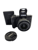 The full used Canon M50 Mark II bundle showing the camera body, lens, strap, and brand new Canon power charging accessories with two batteries at Best Camera Store.