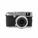 Used Fujifilm FinePix X100 1st Gen in silver color, mint condition front view with 23mm f2 lens at Best Camera Store.