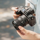 Photographer holding a Nikon mirrorless camera with the Viltrox 35mm F1.8 EVO lens attached at best camera store